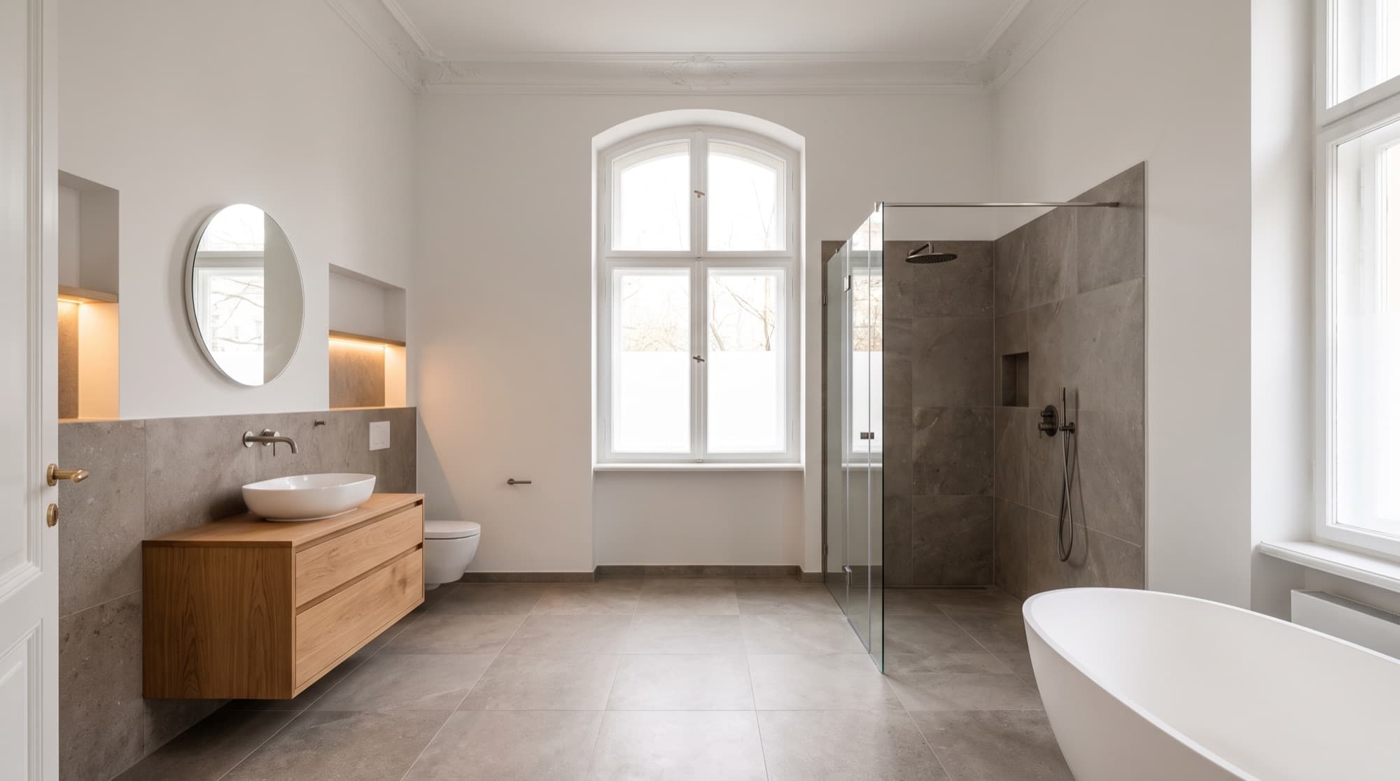 Saniertes Bad in einer Berliner Altbauwohnung mit Stuck, bodengleicher Dusche und freistehender Wanne